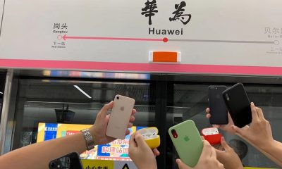 Apple fans posing in train station named after Huawei